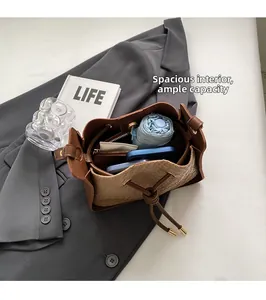 Spacious interior of brown woven bucket bag holding umbrella and phone