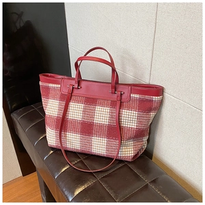 Detail of red and white houndstooth canvas tote bag with premium leather handles