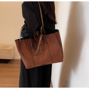Detailed shoulder view of a large brown suede tote bag for commuting and casual use
