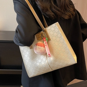 Cream checkered tote bag with brown straps and plush charm for summer commute
