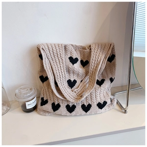 Détails de la maille torsadée du sac cabas beige à motif cœur en fil de coton doux