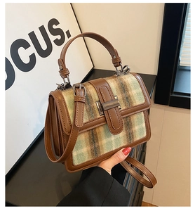 Detail of vintage green plaid wool handbag with brown leather trim and metal clasp