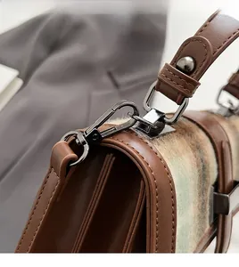 Detail of the detachable gun-metal hardware and leather stitching on the handbag