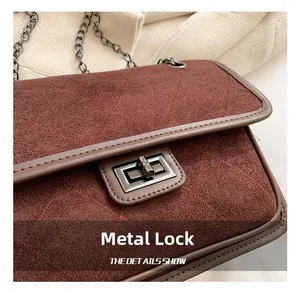 Detail of a shiny silver metal twist lock on a vintage quilted burgundy suede bag