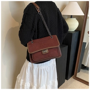Chic burgundy quilted chain bag worn over the shoulder with autumn winter outfit