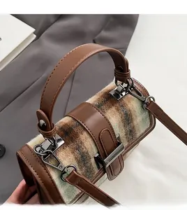 Close-up of the vintage brown plaid fabric texture and leather handle details