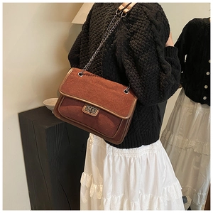 Detail of vintage reddish-brown chain bag with quilted patterns and metal twist lock