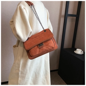 Detail of vintage quilted chain bag in brown faux suede with metallic twist lock