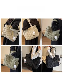 Detail of nylon quilted tote bag with side pockets and fluffy charm shown on model