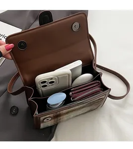 Detail of vintage crossbody bag with double compartments and magnetic closure
