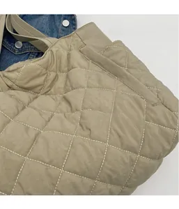 Detail shot of beige quilted nylon tote fabric with elegant diamond stitch patterns
