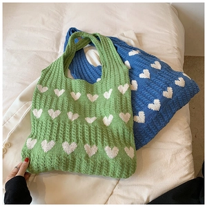 Détails de la maille et motifs de cœur sur les sacs fourre-tout doux vert et bleu
