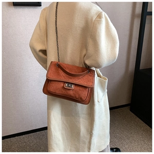 Detail of vintage rhombic chain bag in orange brown with leaf texture and metal lock