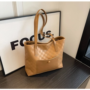 Close-up of brown tote bag with checkered texture and magnetic outer pocket detail