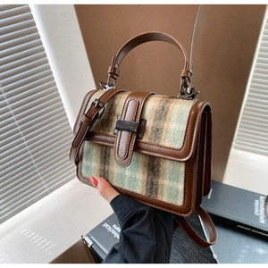 Detail of vintage plaid square handbag showing the premium leather trim and metal lock