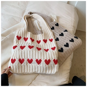 Vue détaillée des sacs cabas tricotés à motif cœur avec texture en fil de coton épais