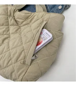 Detail view of khaki nylon quilted tote bag featuring a side zipper pocket and grid texture