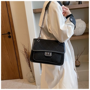 Detail of classic black quilted chain bag with silver turn-lock and matte leather finish