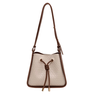 Beige woven leather bucket bag with brown drawstring and adjustable shoulder strap