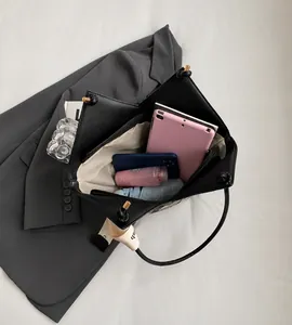 Top view of large black tote bag showing spacious interior with zipper pocket and daily items