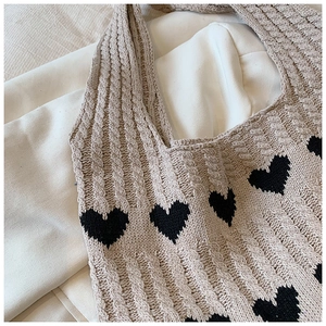 Texture en maille torsadée et motif de cœur noir sur le sac cabas beige doux