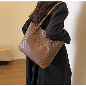 Detail of dark brown checkered weave tote bag with front pocket and long straps