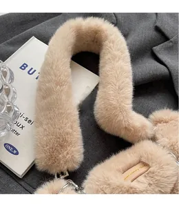 Détail de la bandoulière en peluche beige avec boucle argentée sur une veste grise