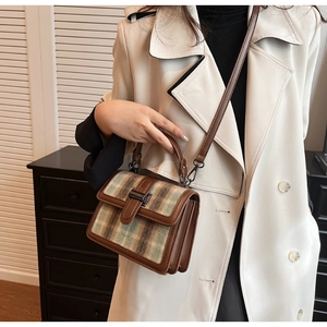 Detail of wool plaid handbag with leather trim and gunmetal metallic buckle closure