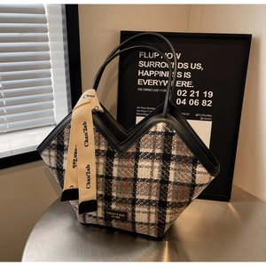 Detailed macro view of the woven checkered fabric and decorative ribbon on the tote bag