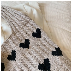 Gros plan sur le motif de cœur et la texture en maille torsadée d'un sac cabas en coton