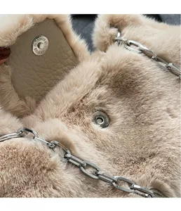 Détail du fermoir magnétique argenté et de la texture pelucheuse du sac beige en fourrure