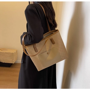 Detail of checkered tote bag with adjustable brown shoulder strap on model