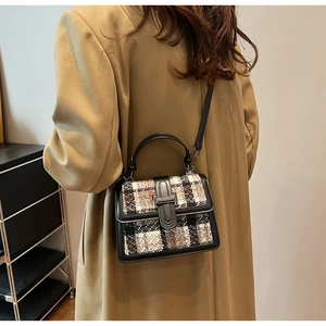 Detail of tweed crossbody bag with metallic clasp and leather strap on model