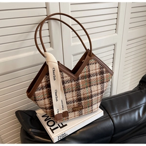Close-up of vintage plaid tote bag with V-cut opening and leather strap detailing