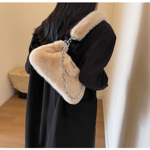 Vue détaillée du sac à bandoulière en peluche beige avec chaîne argentée et coussinet