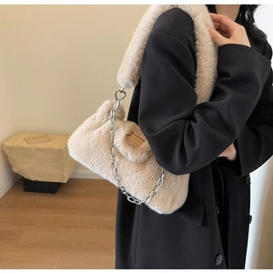 Détail d'un sac à bandoulière en peluche abricot avec chaîne et boucle en cœur