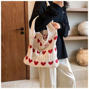 Détail du sac cabas en tricot montrant la texture coton et le motif jacquard coeur