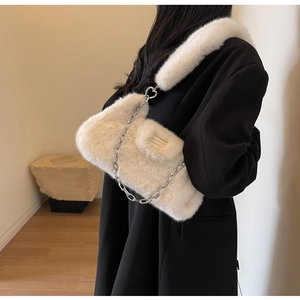 Détail du sac bandoulière en fausse fourrure crème avec chaîne et boucle en cœur