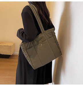 Detail of army green quilted tote bag with front snap pocket and soft padded texture