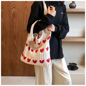 Détail du sac fourre-tout en tricot crème avec motif coeur rouge et tissage épais doux