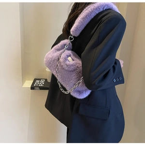 Détail du sac à main en peluche violette avec chaîne argentée et boucle en cœur