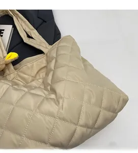 Detailed texture of beige quilted nylon tote bag with soft stitching and plush charm