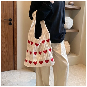 Gros plan du sac cabas en tricot à motif cœur montrant la texture douce du coton tressé