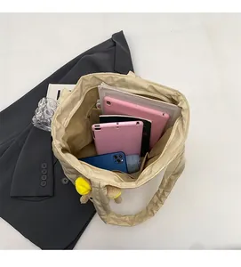 Spacious interior of beige quilted nylon tote bag with tablets and books inside