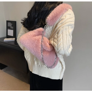 Vue détaillée d'un sac à épaule en fausse fourrure rose avec une chaîne argentée sur modèle