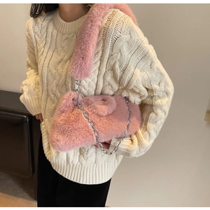 Gros plan du sac en fausse fourrure rose avec chaîne en argent et bandoulière peluche