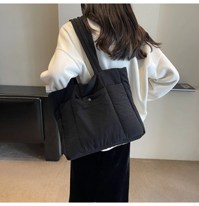 Macro view of black quilted nylon tote bag showing high-quality stitching and texture