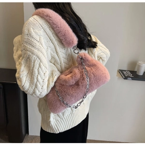 Gros plan détaillé d'un sac à bandoulière en fausse fourrure rose avec chaîne argentée