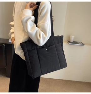 Detail of a large black quilted tote bag made of lightweight down fabric for daily use