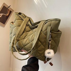 Olive green quilted nylon tote bag with large diamond stitching and plush keychain